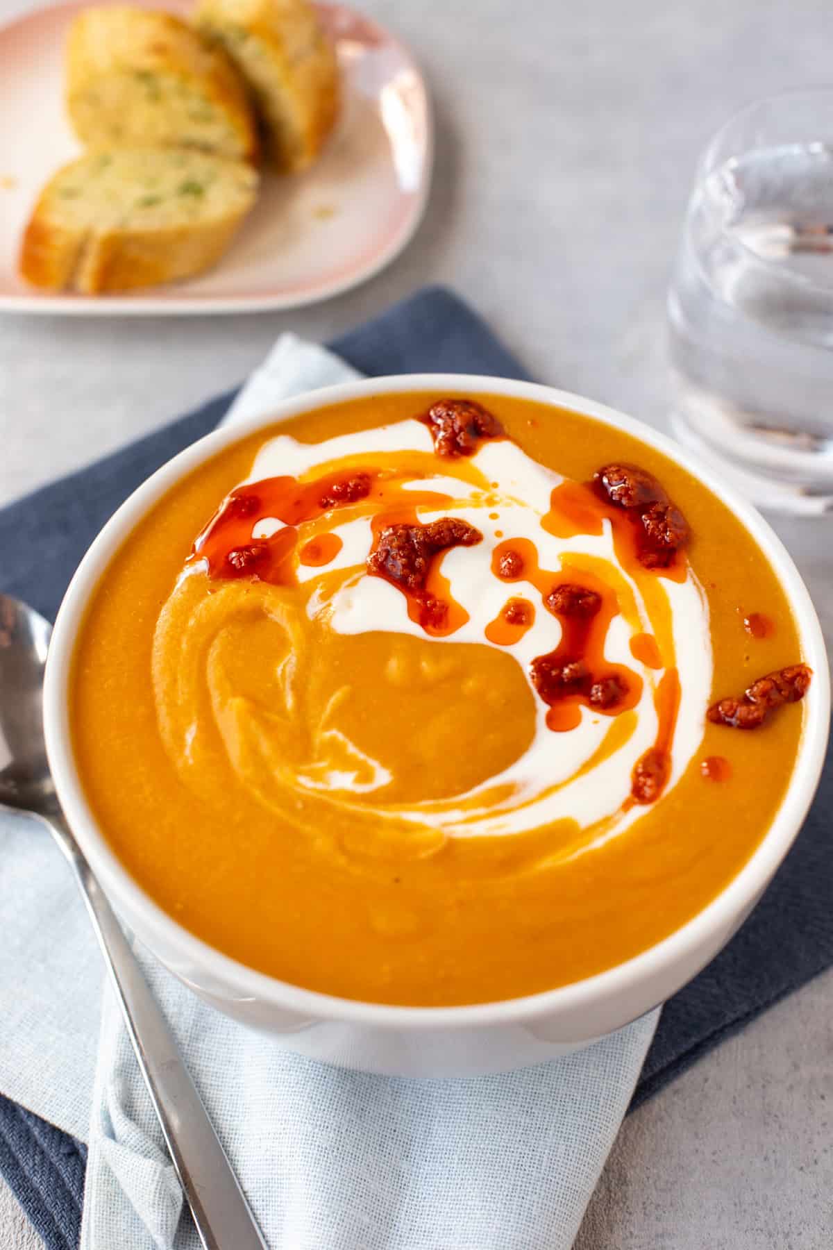 Creamy red lentil soup in a bowl with a swirl of Greek yogurt.