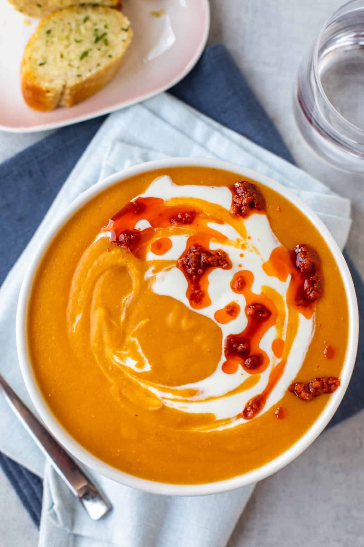 Easy red lentil soup topped with a swirl of yogurt and red pesto.