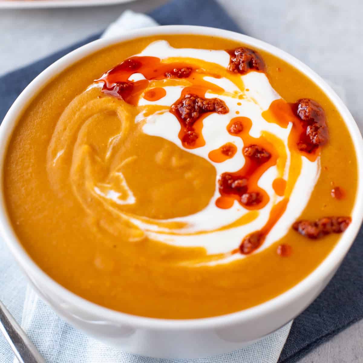 Easy red lentil soup topped with Greek yogurt and red pesto.