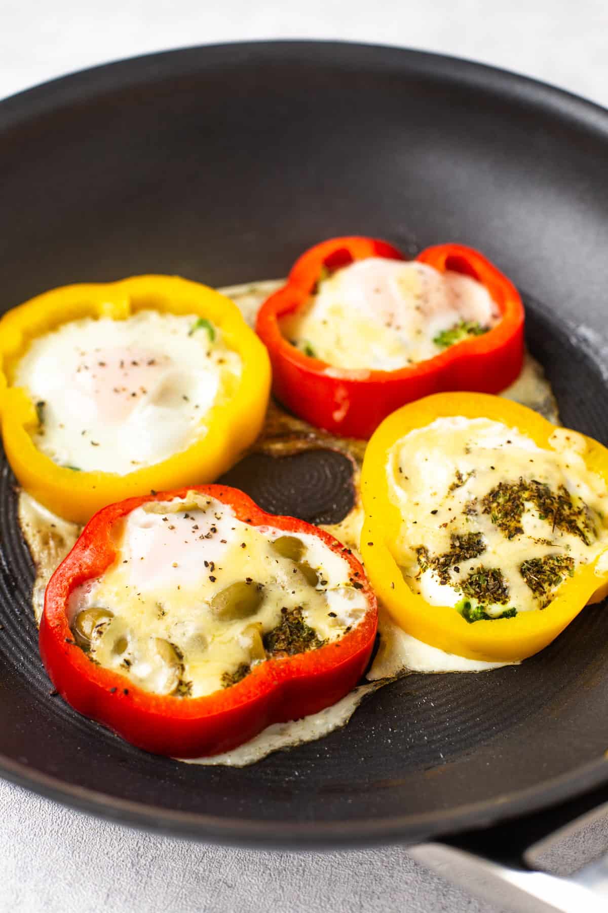 Rings of pepper in a frying pan with fried eggs inside.