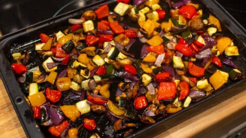 Colourful roasted vegetables on a baking tray.