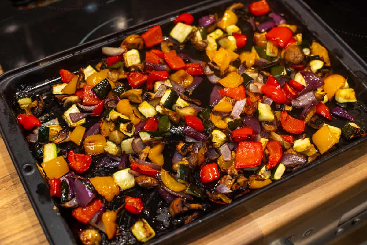 Colourful roasted vegetables on a baking tray.