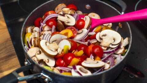 Uncooked Mediterranean vegetables in a frying pan.