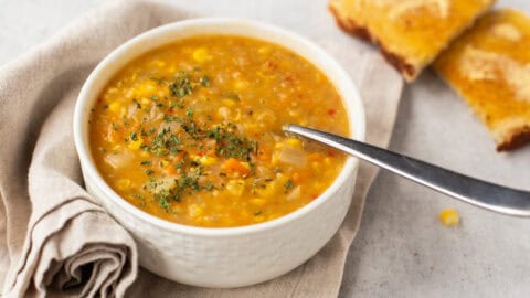 Coconut corn chowder in a bowl with buttered toast.