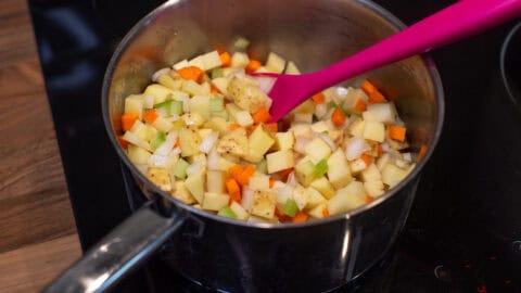 Diced potatoes and other vegetables in a saucepan.