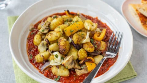 Air fried gnocchi and vegetables served on tomato sauce.