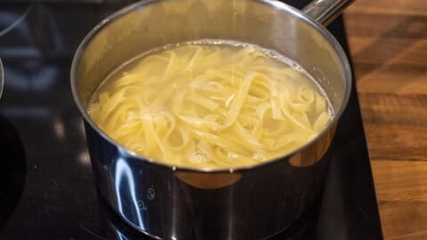 Cooked tagliatelle in a saucepan of water.