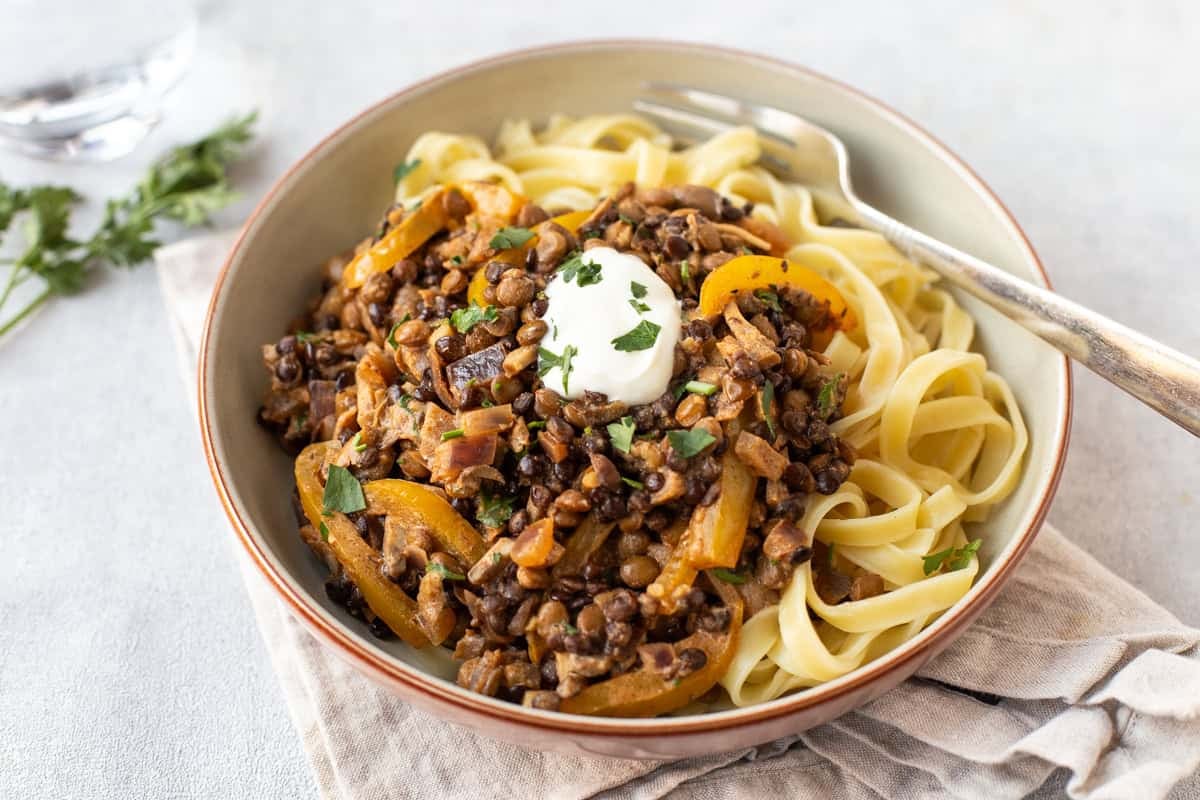 A bowl of tagliatelle topped with easy lentil stroganoff.