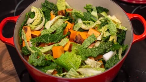 Chopped cabbage, onion and sweet potato in a large casserole dish.