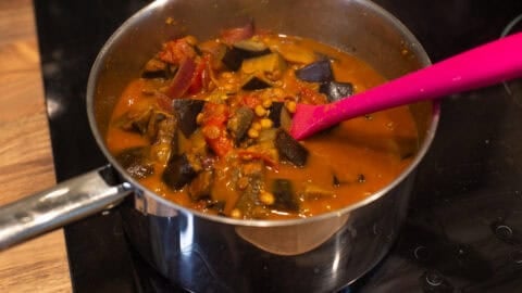 Eggplant curry cooking in a saucepan.