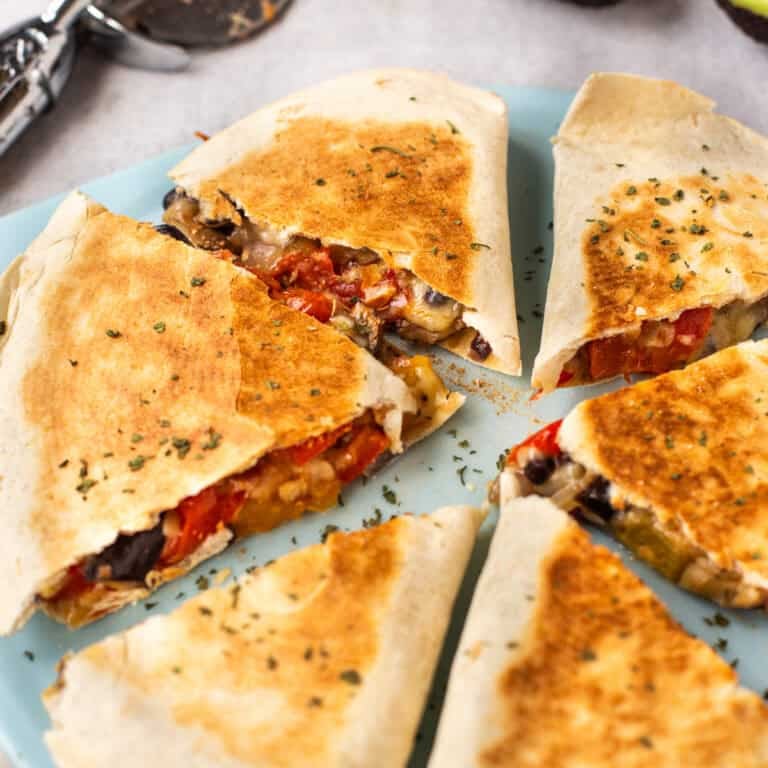Slices of roasted vegetable quesadillas on a cutting board.
