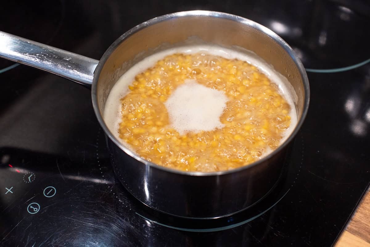 Red lentils cooking in a saucepan.