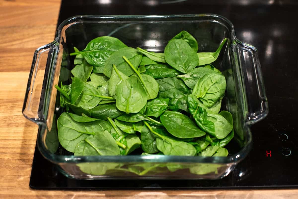 Spinach laid out in a baking dish.