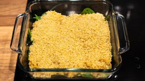 Uncooked orzo in a baking dish.