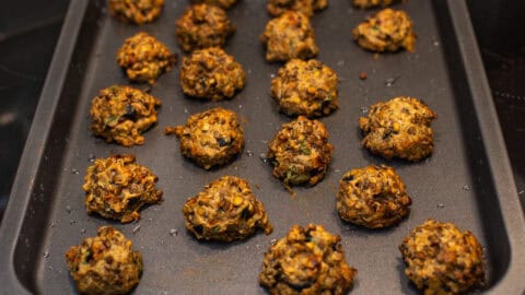 Crispy vegetarian Mediterranean lentil meatballs on a baking tray.