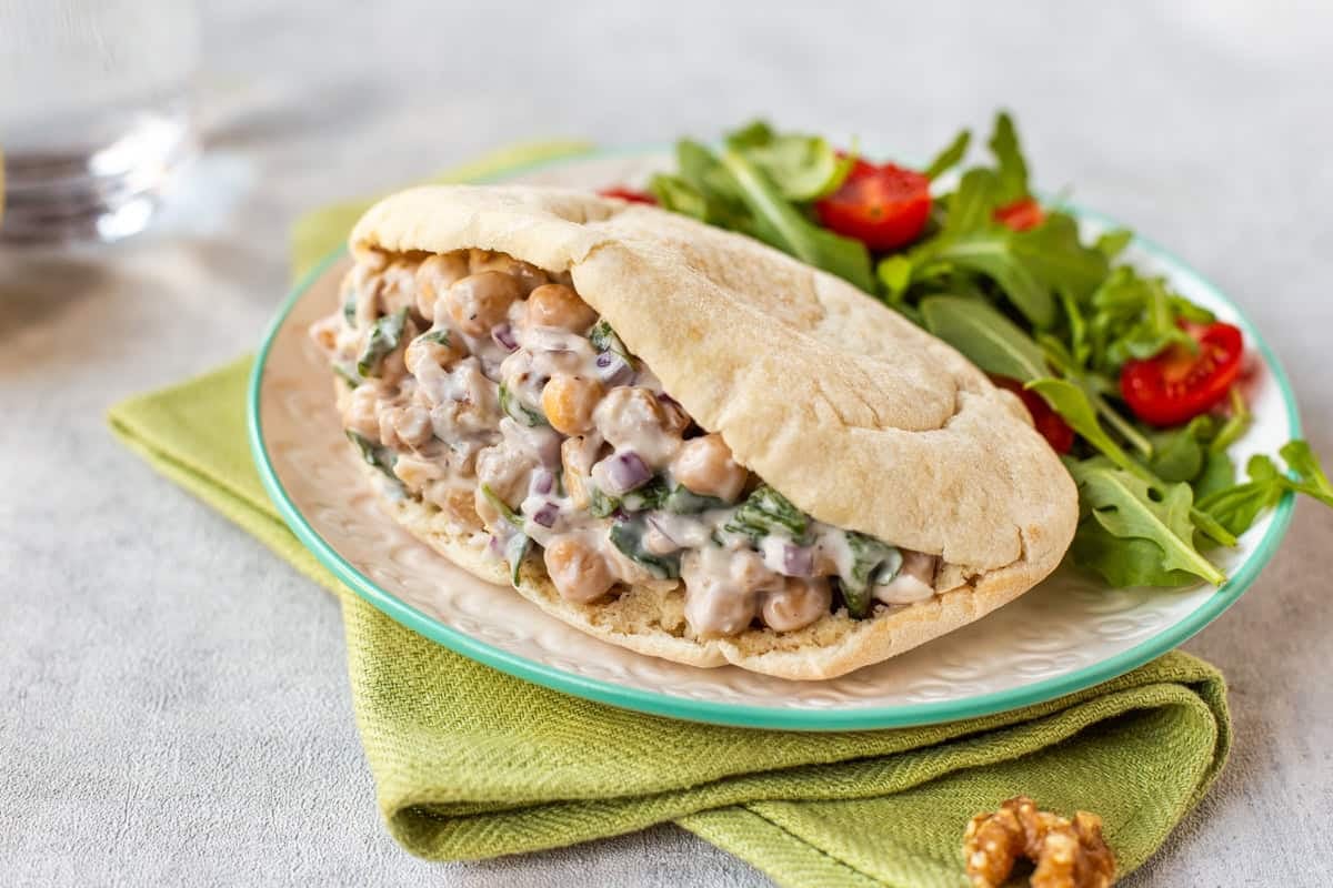 Creamy chickpea salad with goat cheese and walnuts in a pitta bread.
