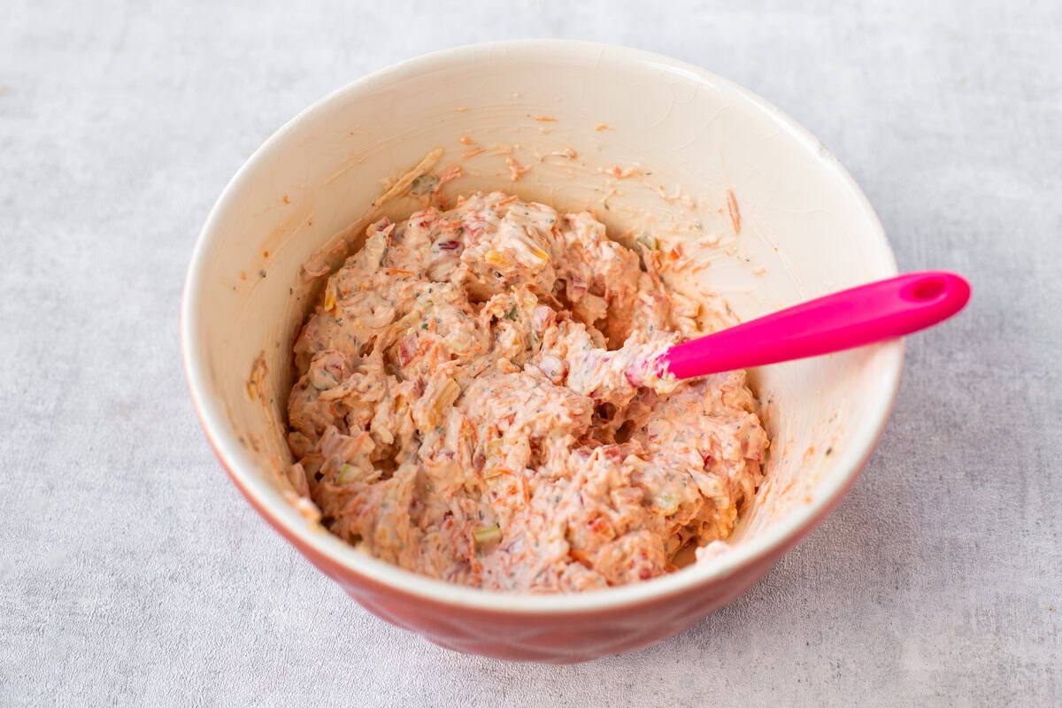 A mixing bowl full of a vegetable cream cheese mixture.