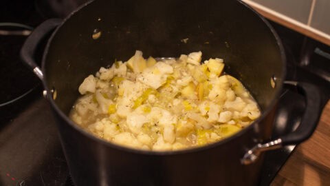 Cooked potatoes, cauliflower and leeks with vegetable stock in a large saucepan.