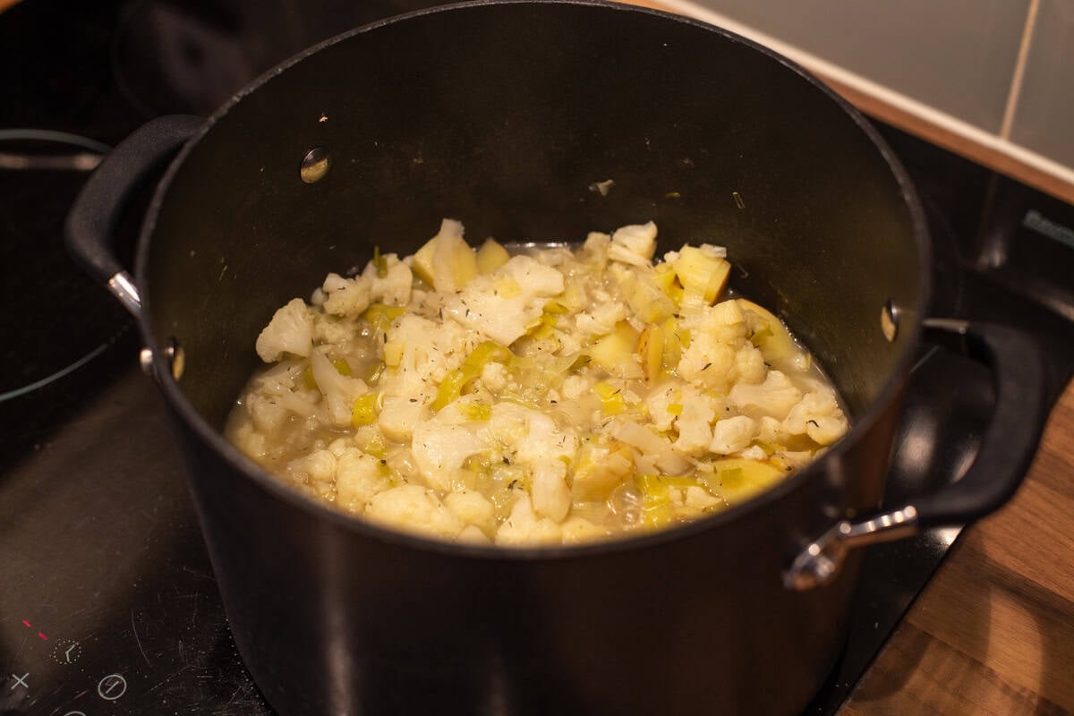 Cooked potatoes, cauliflower and leeks with vegetable stock in a large saucepan.