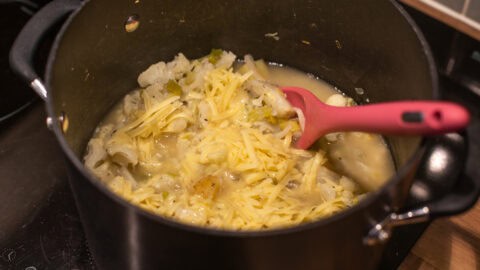 Unblended cauliflower soup with cheese in a large saucepan.
