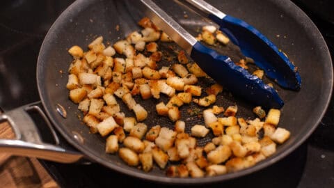 Small and crispy homemade croutons in a frying pan.