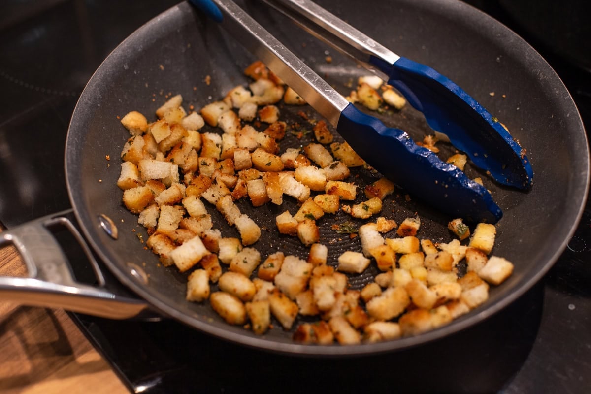Small and crispy homemade croutons in a frying pan.