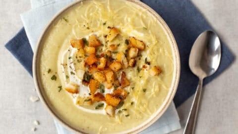 A bowl of creamy cauliflower soup with croutons.