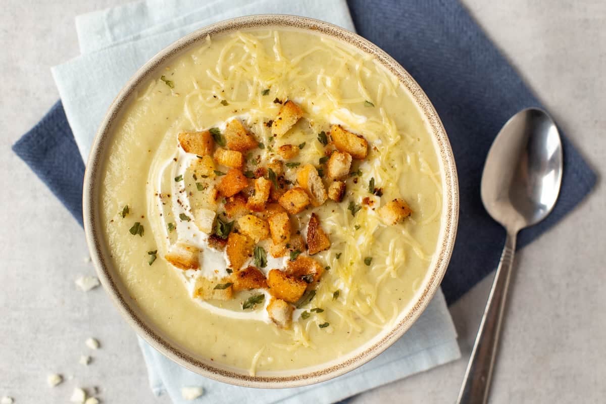 A bowl of creamy cauliflower soup with croutons.