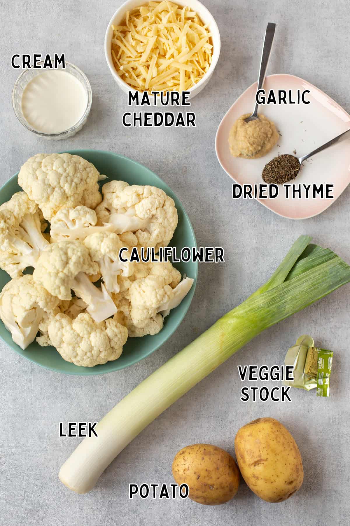 Ingredients for creamy cauliflower cheese soup laid out with text overlay.