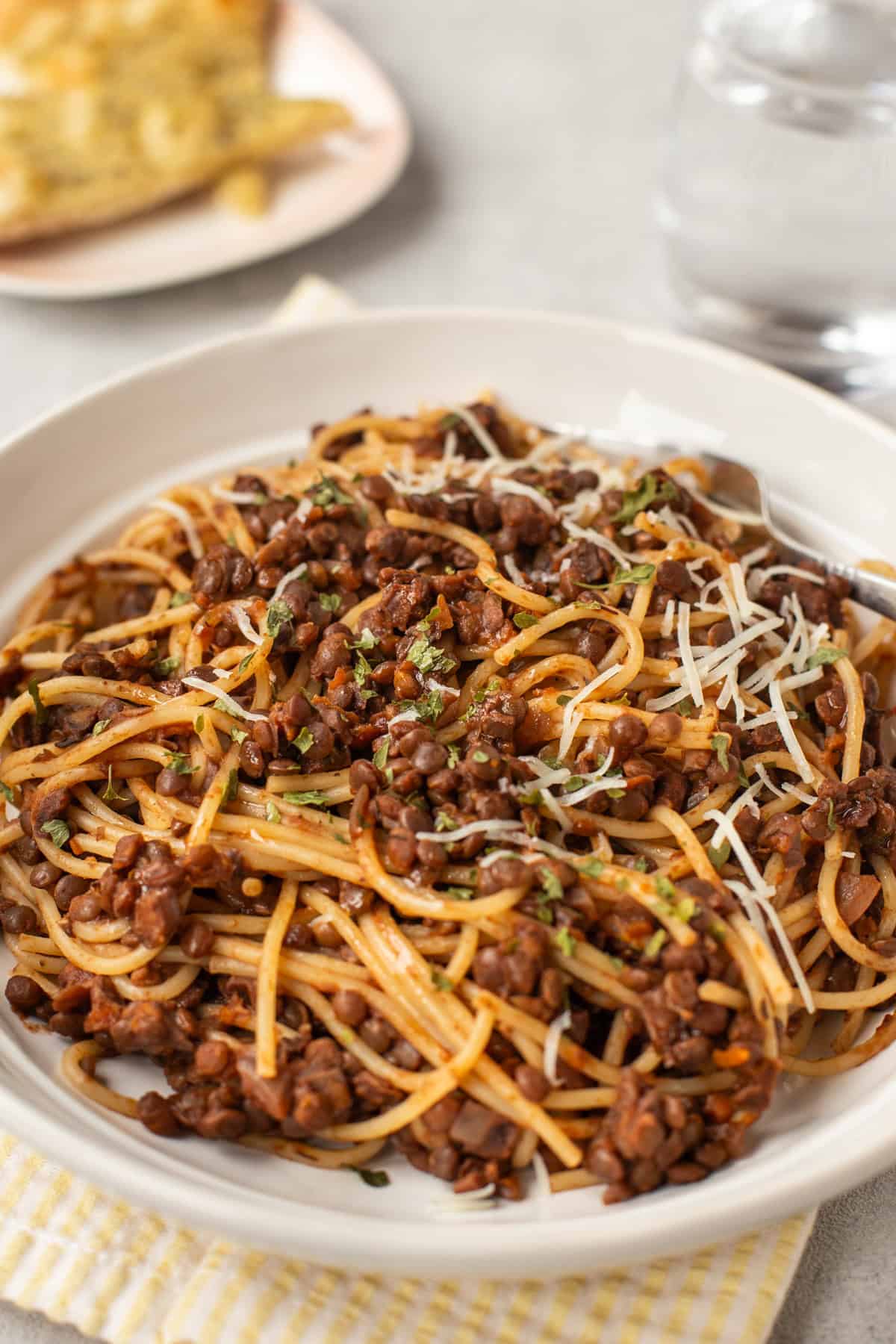 A portion of spaghetti with lentil bolognese in a bowl.