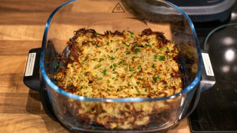 Crispy homemade hash browns in an air fryer topped with chives.