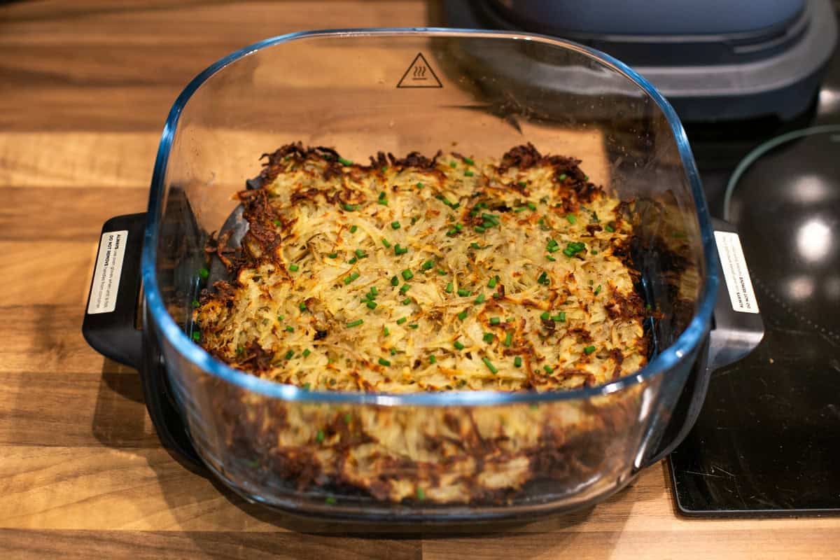 Crispy homemade hash browns in an air fryer topped with chives.