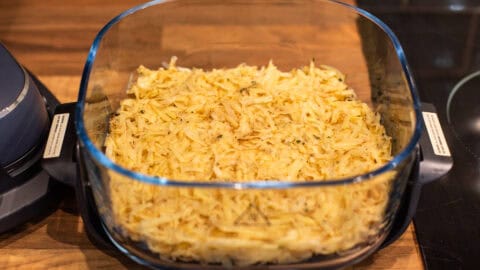 Grated potato pressed into an air fryer container.
