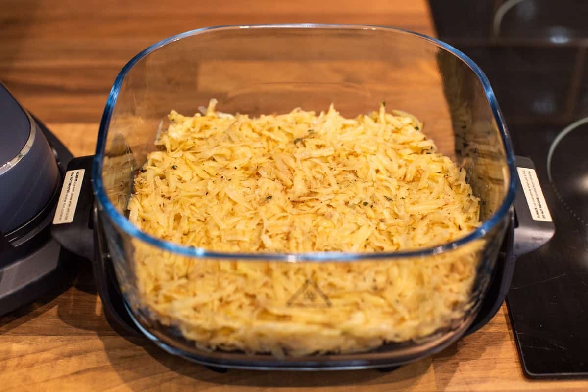 Grated potato pressed into an air fryer container.