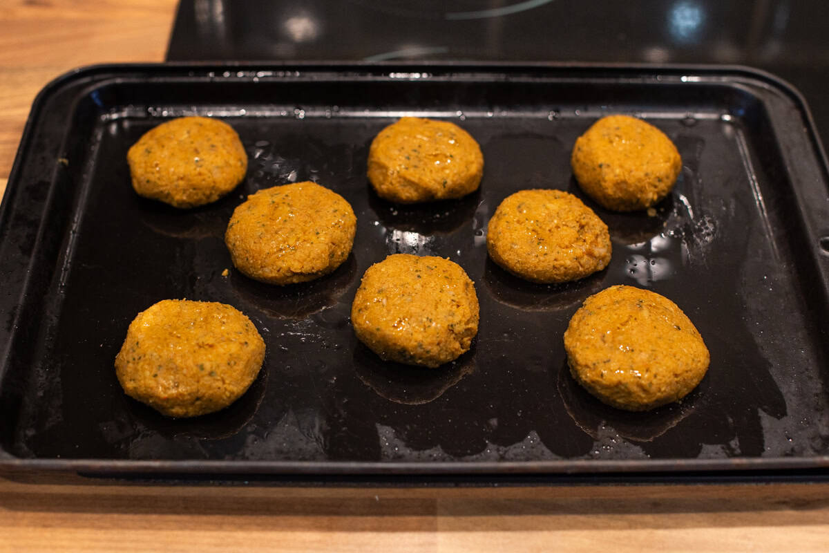 Uncooked homemade falafel on a baking tray.