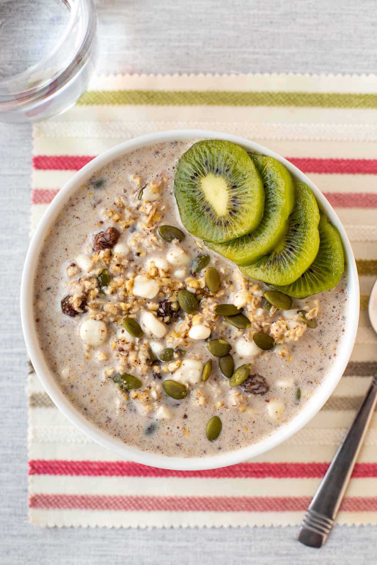 Overhead shot of a bowl of high protein overnight oats topped with sliced kiwi.