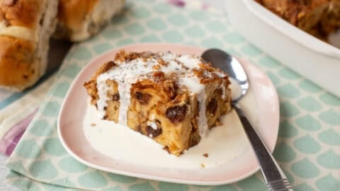 A portion of bread and butter pudding with cream.