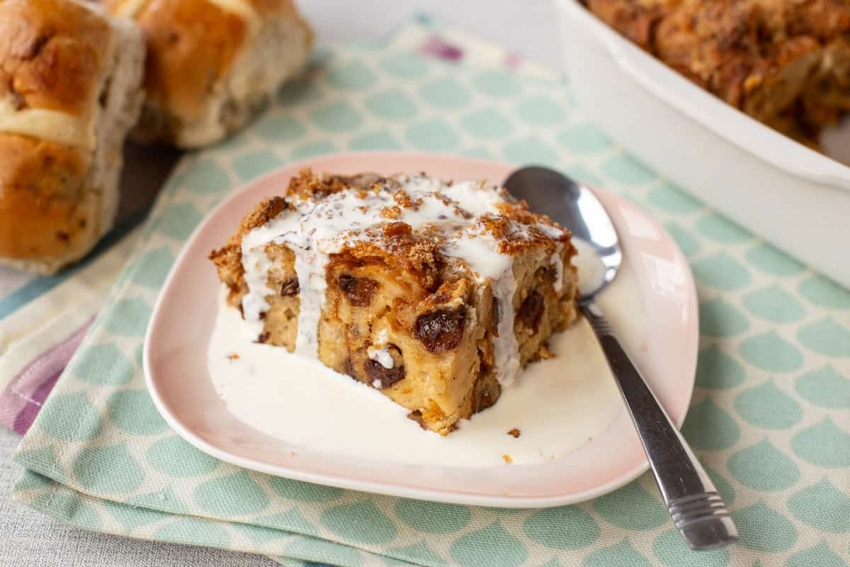 A portion of bread and butter pudding with cream.