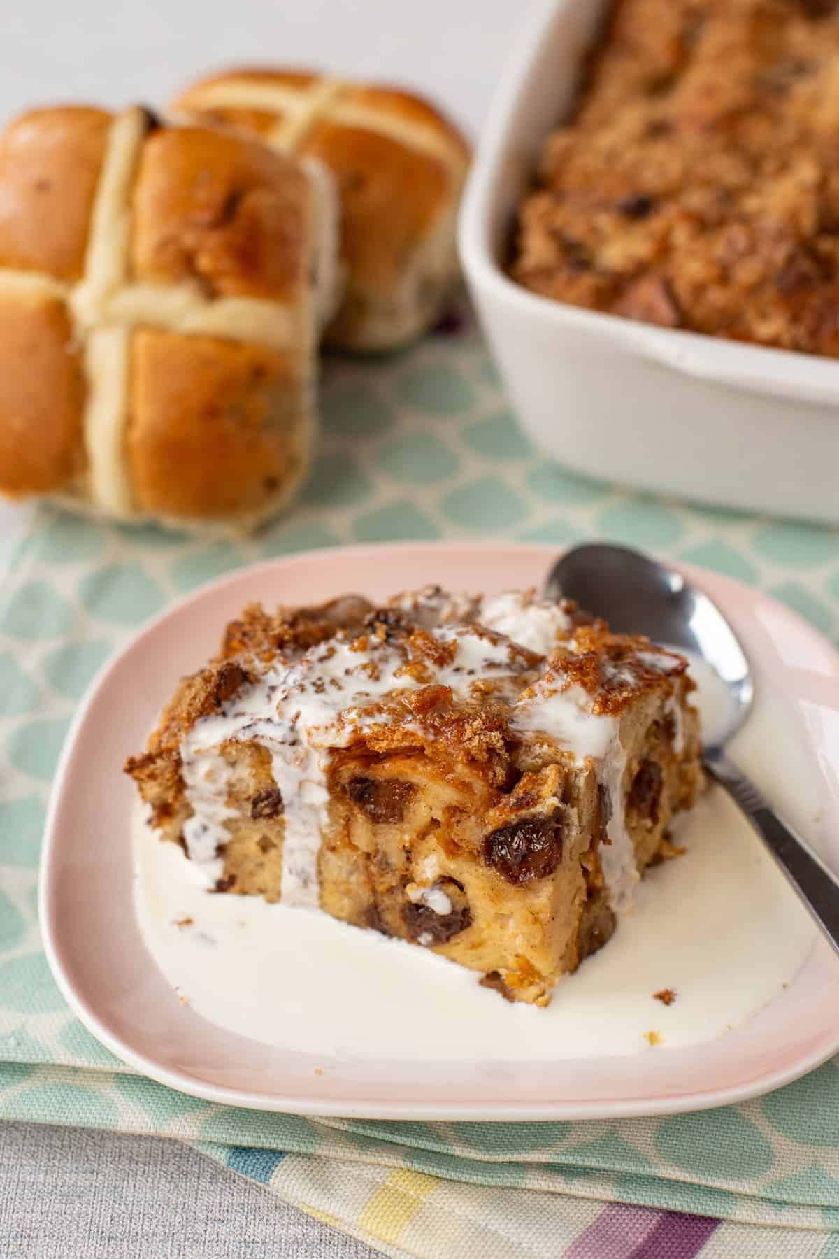 A portion of hot cross bun bread pudding with cream.