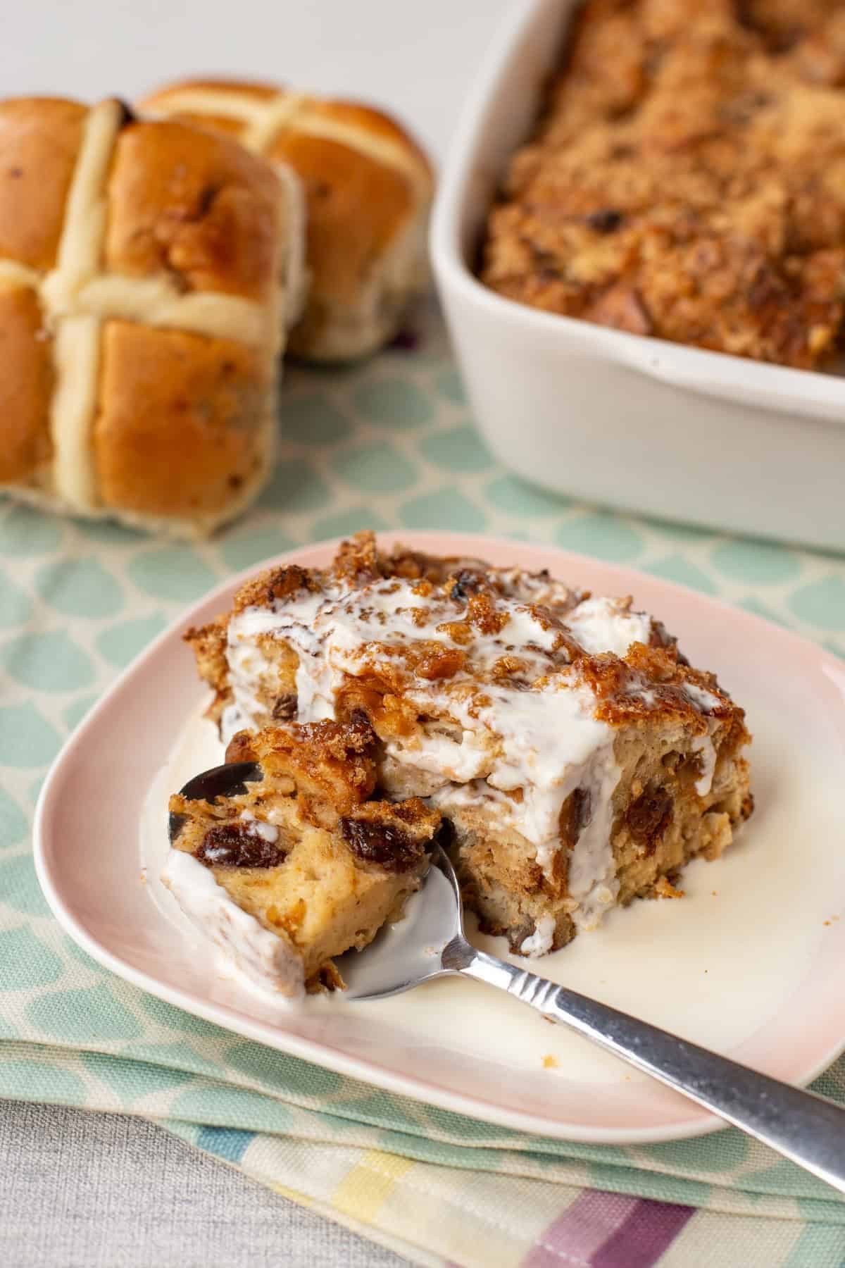 A spoon taking a scoop of hot cross bun bread pudding.
