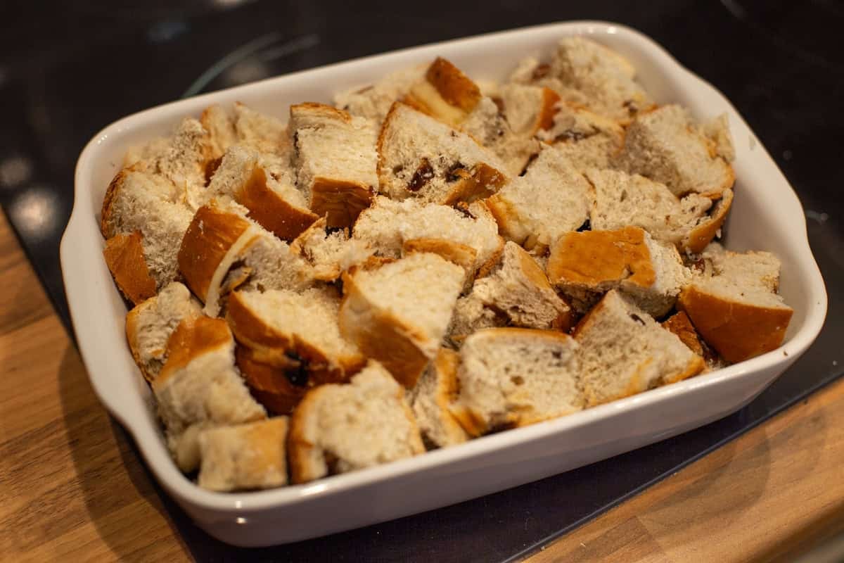 Diced hot cross buns in a baking dish.