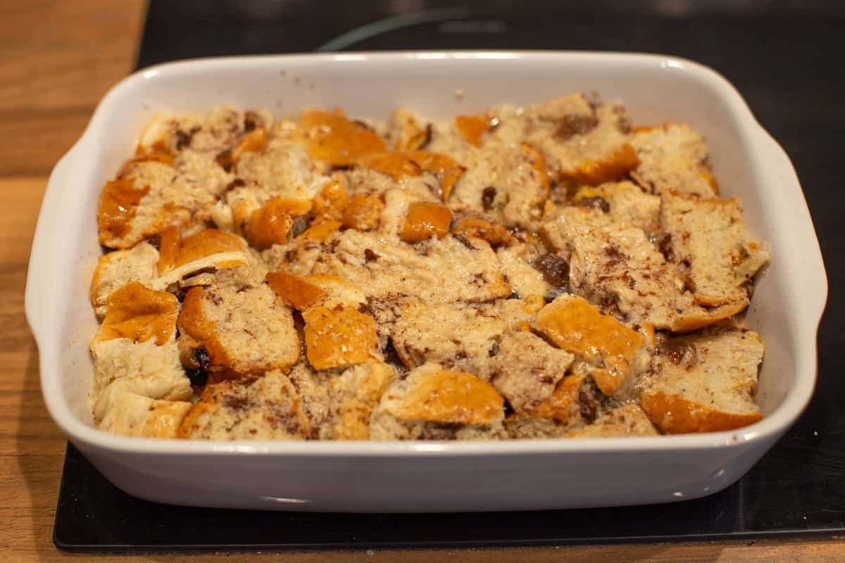 Diced hot cross buns in a dish, soaked in egg custard.