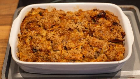 A crispy bread and butter pudding in a dish, topped with crispy brown sugar.