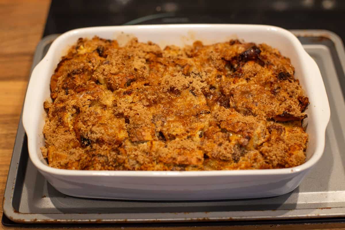 A crispy bread and butter pudding in a dish, topped with crispy brown sugar.