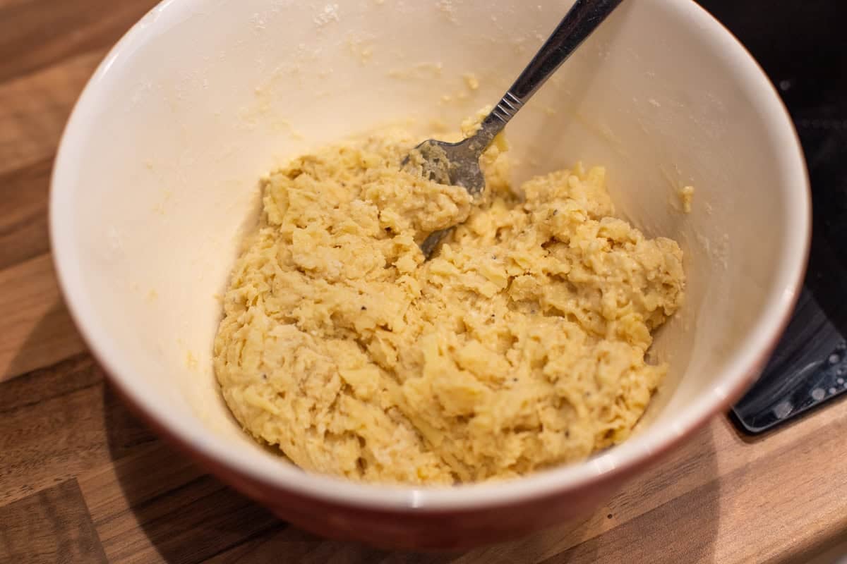 Uncooked cheese scone mixture in a mixing bowl.