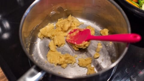 A roux made from butter and flour cooking in a saucepan.
