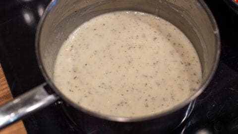 Seasoned white sauce in a saucepan.