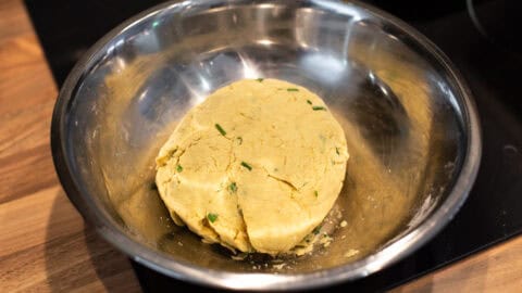 A ball of hummus scone dough in a mixing bowl.
