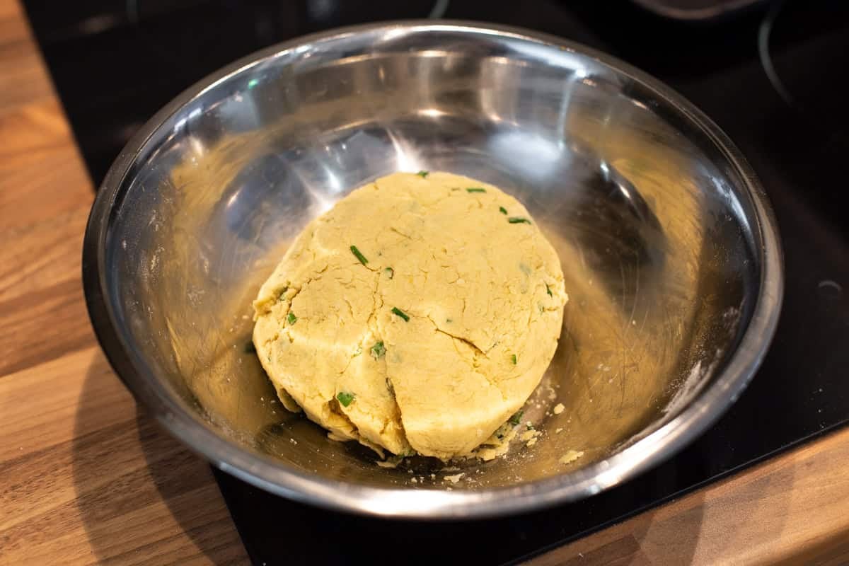 A ball of hummus scone dough in a mixing bowl.