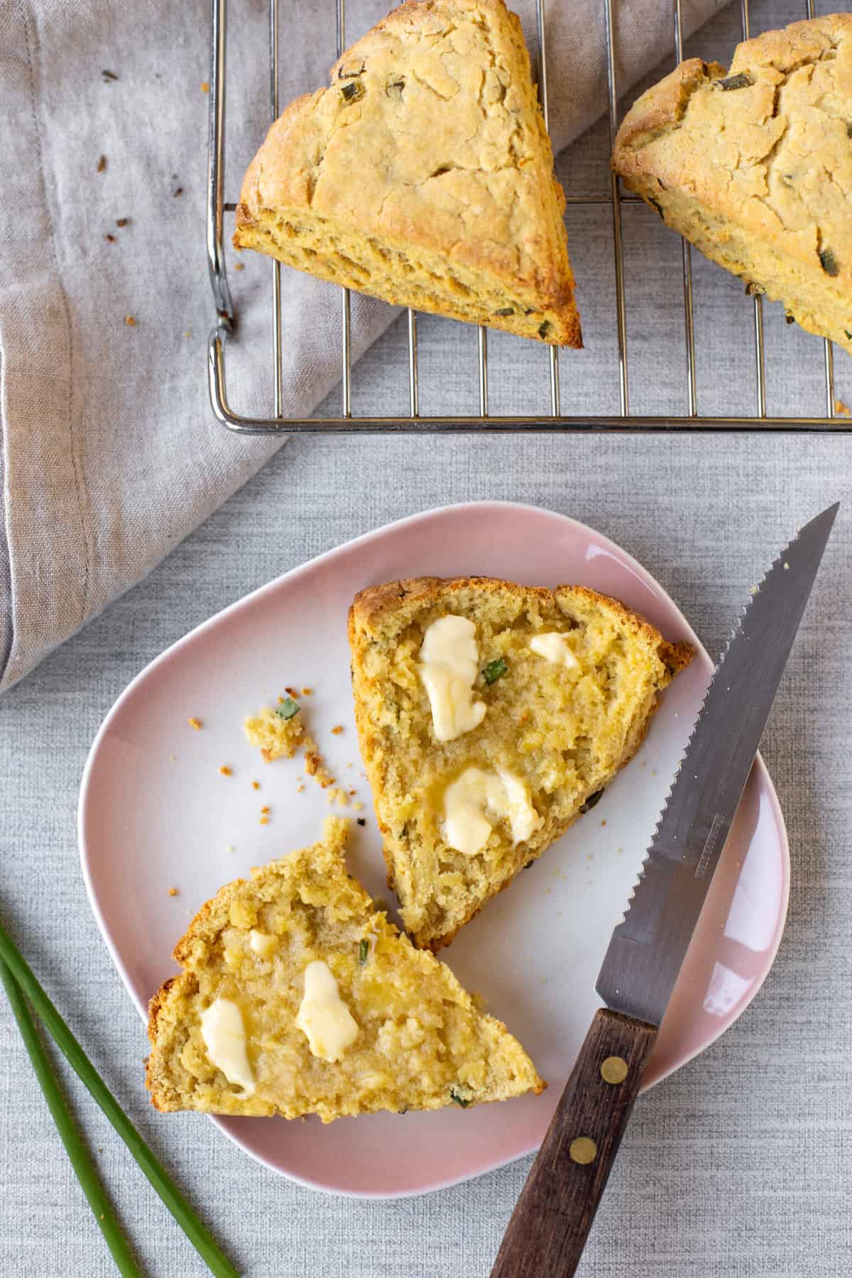 Overhead shot of a homemade hummus scone cut in half and spread with melty butter.